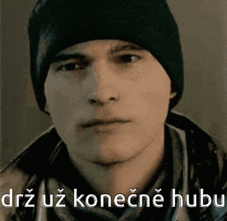 a man wearing a black hat and scarf is looking at the camera with a foreign language caption .