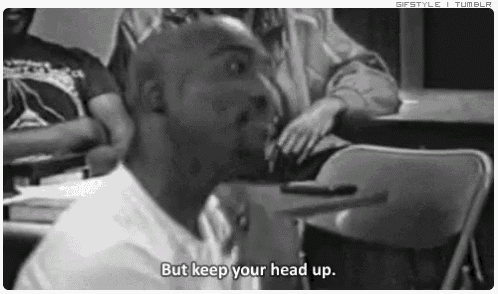 a black and white photo of a man sitting at a table with the words but keep your head up .
