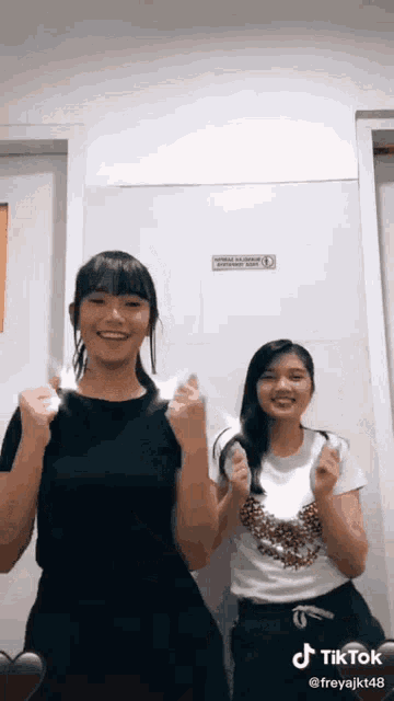 two girls are standing next to each other with their hands in the air and a tiktok watermark at the bottom