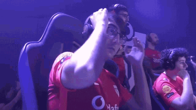 a man wearing headphones and a red shirt that says ' dda ' on it
