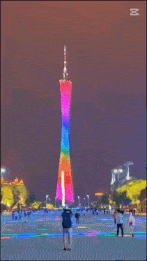a person standing in front of a rainbow colored tower with the letter m on the bottom