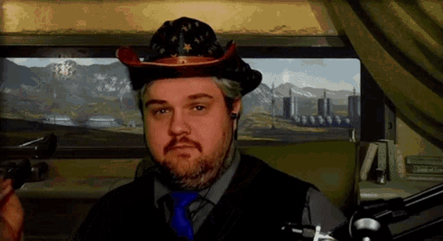 a man wearing a cowboy hat and a blue tie