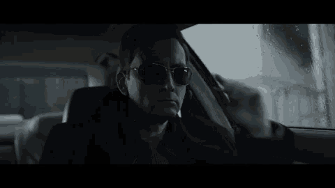 a man is sitting in the driver 's seat of a car .