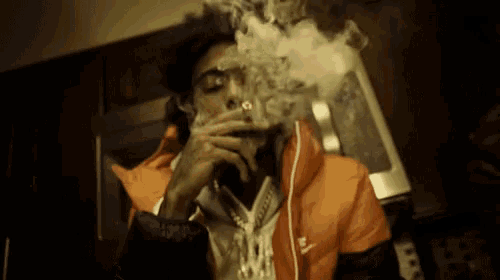 a man in an orange nike jacket is smoking