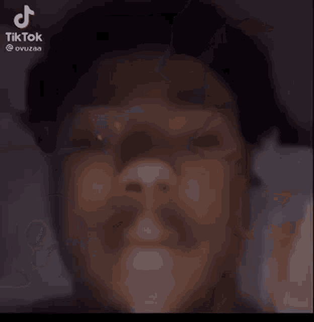 a close up of a man 's face with a cartoon character behind him and a tiktok logo in the corner