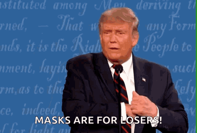 donald trump says that masks are for losers in front of a blue background