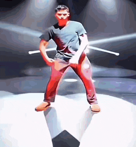 a man in a black shirt and red pants is holding two sticks