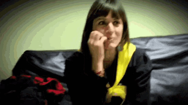 a woman is sitting on a couch with her hand on her face