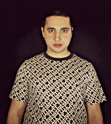 a man wearing a black and white t-shirt with a geometric pattern on it