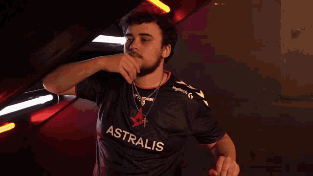 a man wearing a black shirt that says ' astralis ' on the front