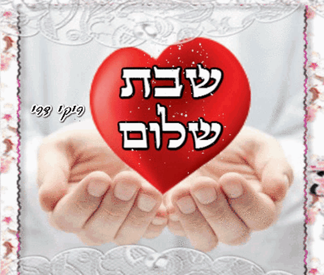 a person holding a red heart in their hands with hebrew writing on it