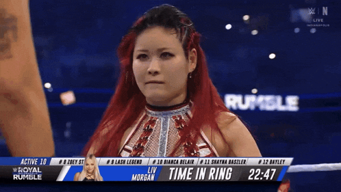 a woman with red hair is standing in a wrestling ring with the time in ring 2:47
