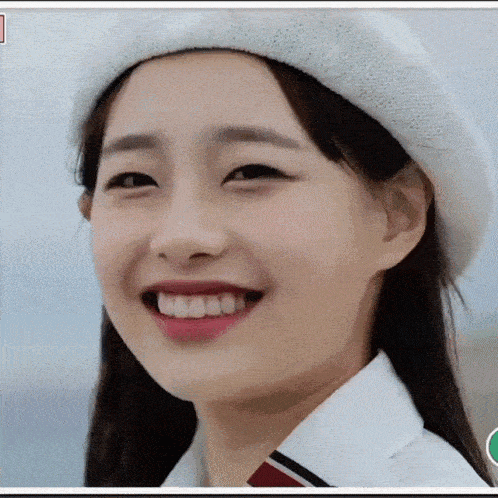 a close up of a woman wearing a white hat smiling