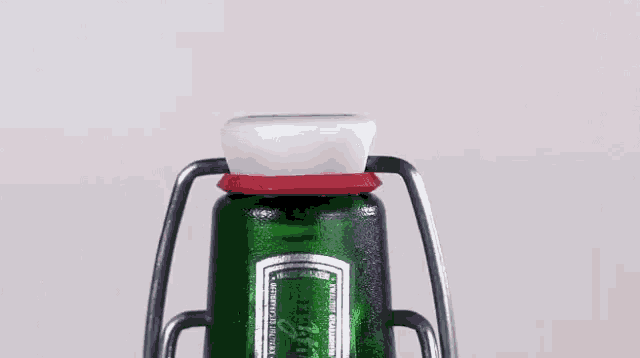 a close up of a green bottle with a red cap on it