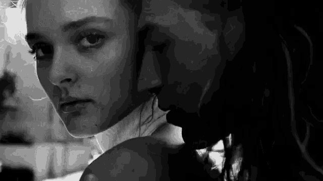 a man and a woman are kissing in a black and white photo .