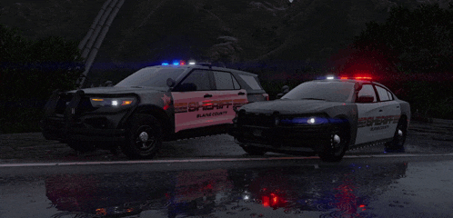 two sheriff cars are parked next to each other in the rain