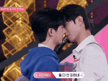 two young men are kissing each other with a sign that says ' i ' on it