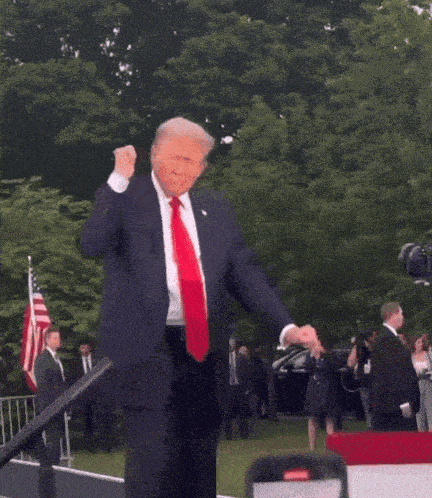 a man in a suit and tie is dancing in front of a crowd