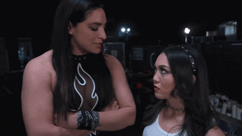 a woman with long hair stands next to another woman