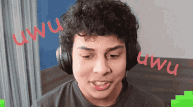 a man wearing headphones has the word uwu written in red on his face
