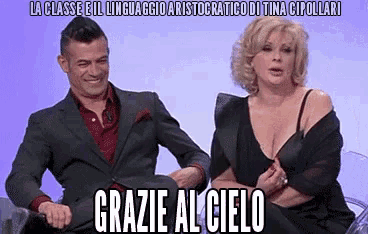 a man and a woman are sitting next to each other and the woman is wearing a bra
