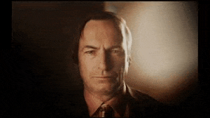 a man in a suit and tie is looking at the camera with a serious look on his face .