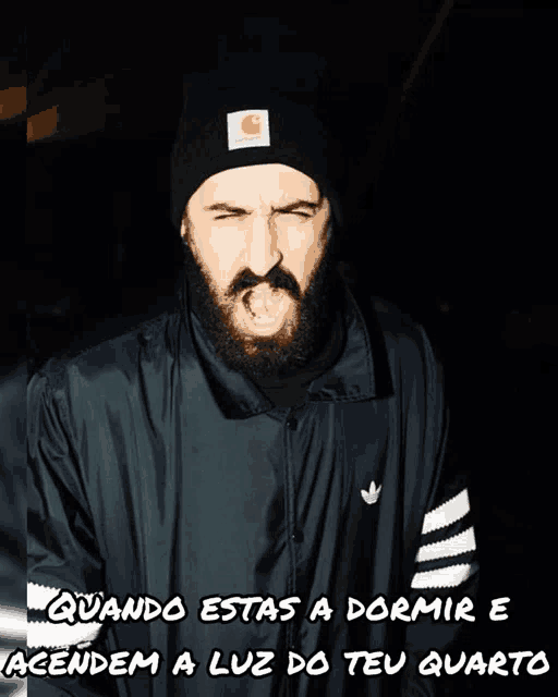 a man with a beard wearing a carhartt hat