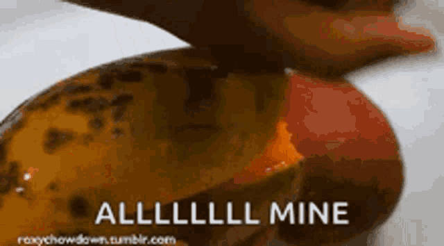 a close up of a person peeling an apple with the words alllll mine written on the bottom