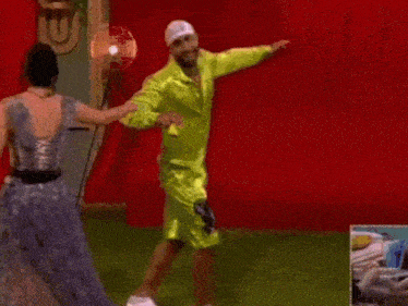a man in a green shirt is dancing with a woman