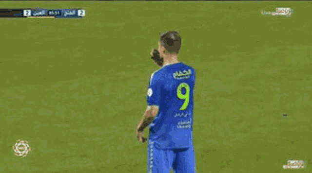 two soccer players are hugging each other on the field . one of the players has the number 9 on his jersey .