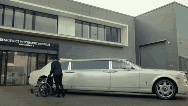 a white limousine is parked in front of a building that says sienkiewicz psychiatric hospital main entrance