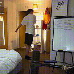 a man in a white shirt is standing in a room with a white board on the wall that says 310