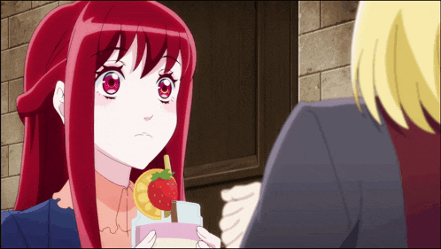 a girl with red hair is holding a drink with a strawberry on it