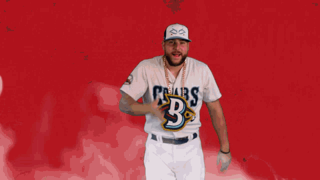 a man wearing a baseball uniform with the letter b on the front