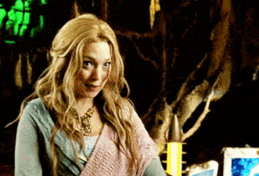 a woman with blonde hair is wearing a blue shirt and a pink sweater