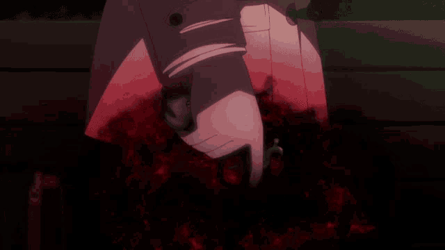a person 's arm is covered in blood and a red light is shining on it