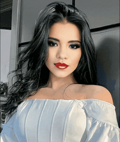 a woman wearing a white off the shoulder top with red lipstick