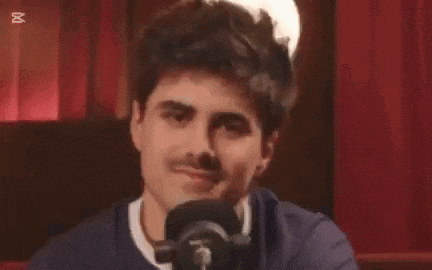a man is making a funny face in front of a microphone .