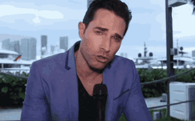 a man in a blue jacket is holding a microphone