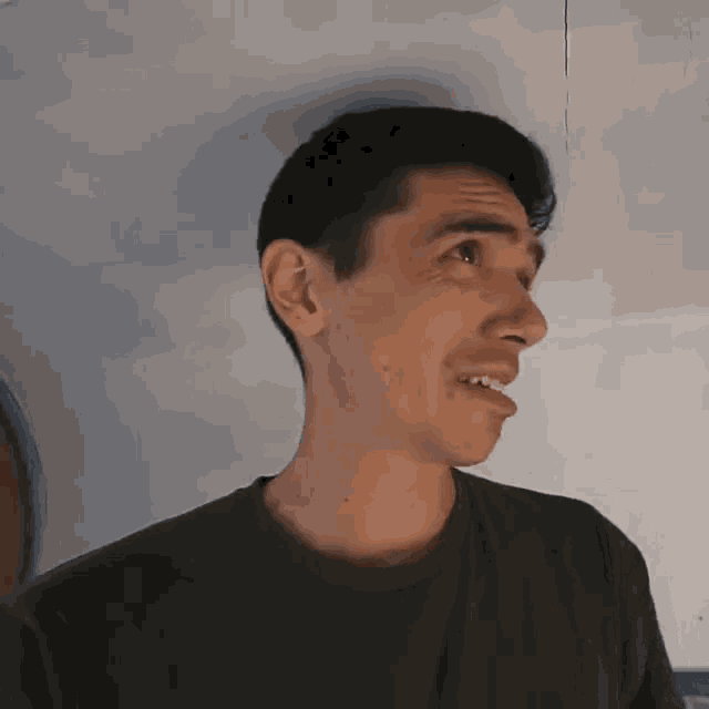 a man wearing a black shirt is making a face