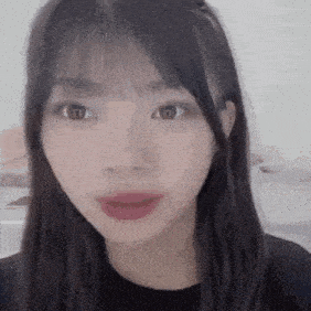a close up of a young woman 's face with long hair and bangs .