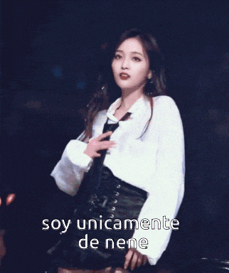 a woman in a white shirt and black skirt is holding a microphone and says soy unicamente de nene