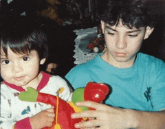 a boy in a blue shirt is holding a stuffed animal