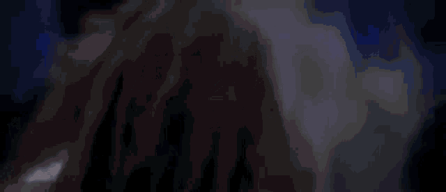 a man is holding a woman in a dark room .