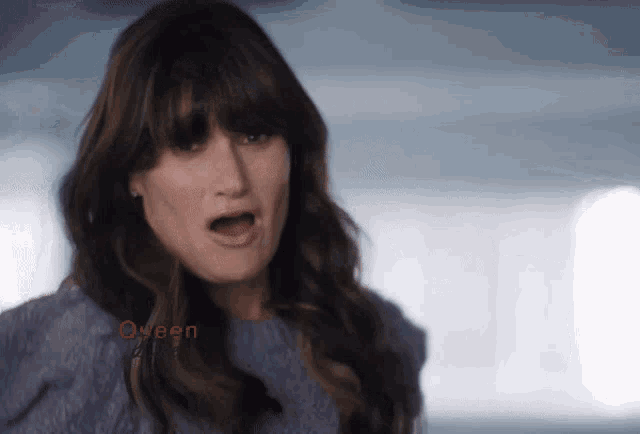 a woman wearing a blue sweater with the word queen on the bottom right
