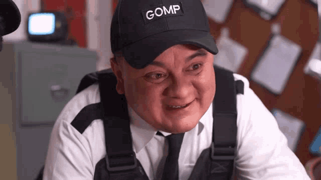 a man wearing a black cap that says gomp on it