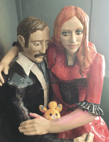 a statue of a man and a woman with a stuffed animal