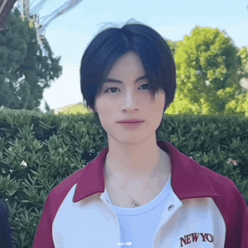 a young man wearing a white shirt and a red jacket with the word new york on it