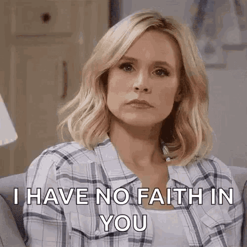 a woman is sitting on a couch with a plaid shirt on and says `` i have no faith in you '' .