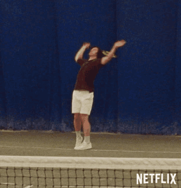 a man is playing tennis on a court with a netflix logo behind him